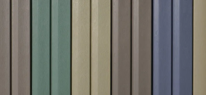 Close-up of a vertical wooden fence with panels painted in muted colors, including green, beige, brown, and blue shades.